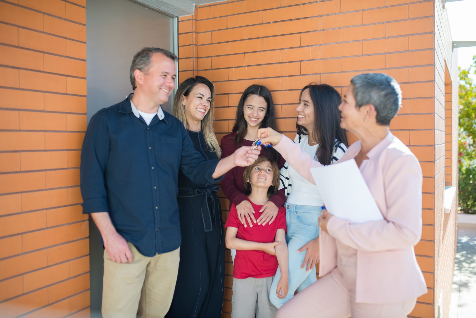 Family receiving keys from a real estate professional